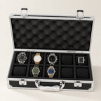 10-slot aluminum watch case with black panels, open with seven watches