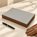 12-slot walnut grain watch storage box closed, beside a fountain pen and leather gloves