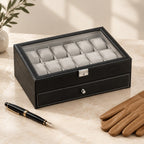 Black two-tier watch box closed, beside a fountain pen and leather gloves