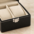 Close-up of the cream pillow, white stitching and metal clasp of the watch box