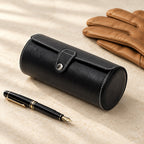 Black watch roll closed, beside a fountain pen and leather gloves