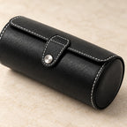 Close-up of the white stitching, tab and metal snap of the black watch roll