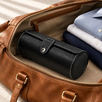 3-Slot Black Leather Watch Roll packed in a leather weekender bag, beside folded shirts