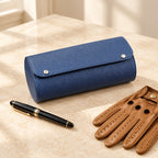 3-slot navy watch roll closed, beside a fountain pen and leather gloves