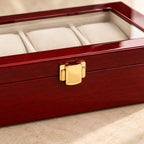 Close-up of the gold-tone clasp and red lacquer of the 3-slot watch box