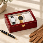 3-slot red lacquered watch box closed, beside a fountain pen and leather gloves