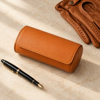 3-slot watch roll closed, beside a fountain pen and leather gloves