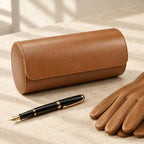 3-watch travel roll closed, beside a fountain pen and leather gloves