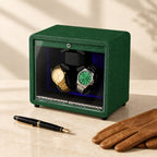 Green leather 3-watch winder closed, beside a fountain pen and leather gloves