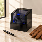 Lit 3-watch winder closed, beside a fountain pen and leather gloves