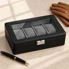 4-slot black watch box closed, beside a fountain pen and leather gloves