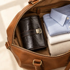 4-slot leather roll-up watch pouch packed in an open leather weekender bag