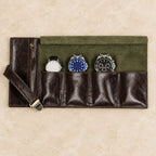 Top view of the open 4-slot leather roll-up watch pouch with watches of different sizes