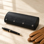 Black 6-slot watch case closed, beside a fountain pen and leather gloves