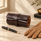 6-slot leather watch roll tied, beside a fountain pen and leather gloves