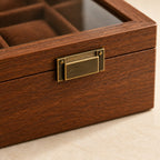 Close-up of the walnut grain and bronze-tone clasp of the 6-slot watch box