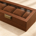 Close-up of the walnut grain and bronze-tone clasp of the 6-slot watch box