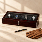 Ebony 8-watch winder box closed, beside a fountain pen and leather gloves