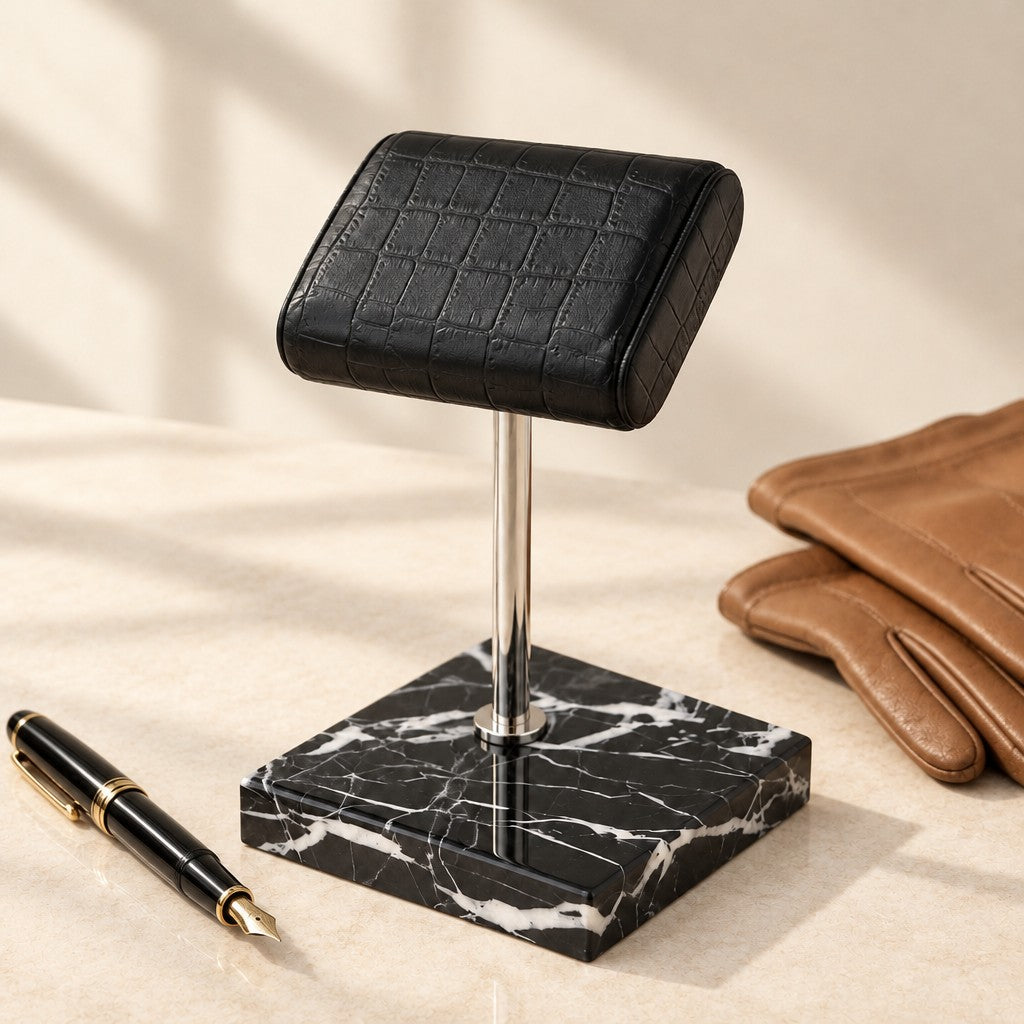 Natural Black Marble Watch Stand with Genuine Leather Pillow beside a fountain pen and leather gloves
