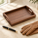 Black walnut valet tray with handles, beside a fountain pen and leather gloves
