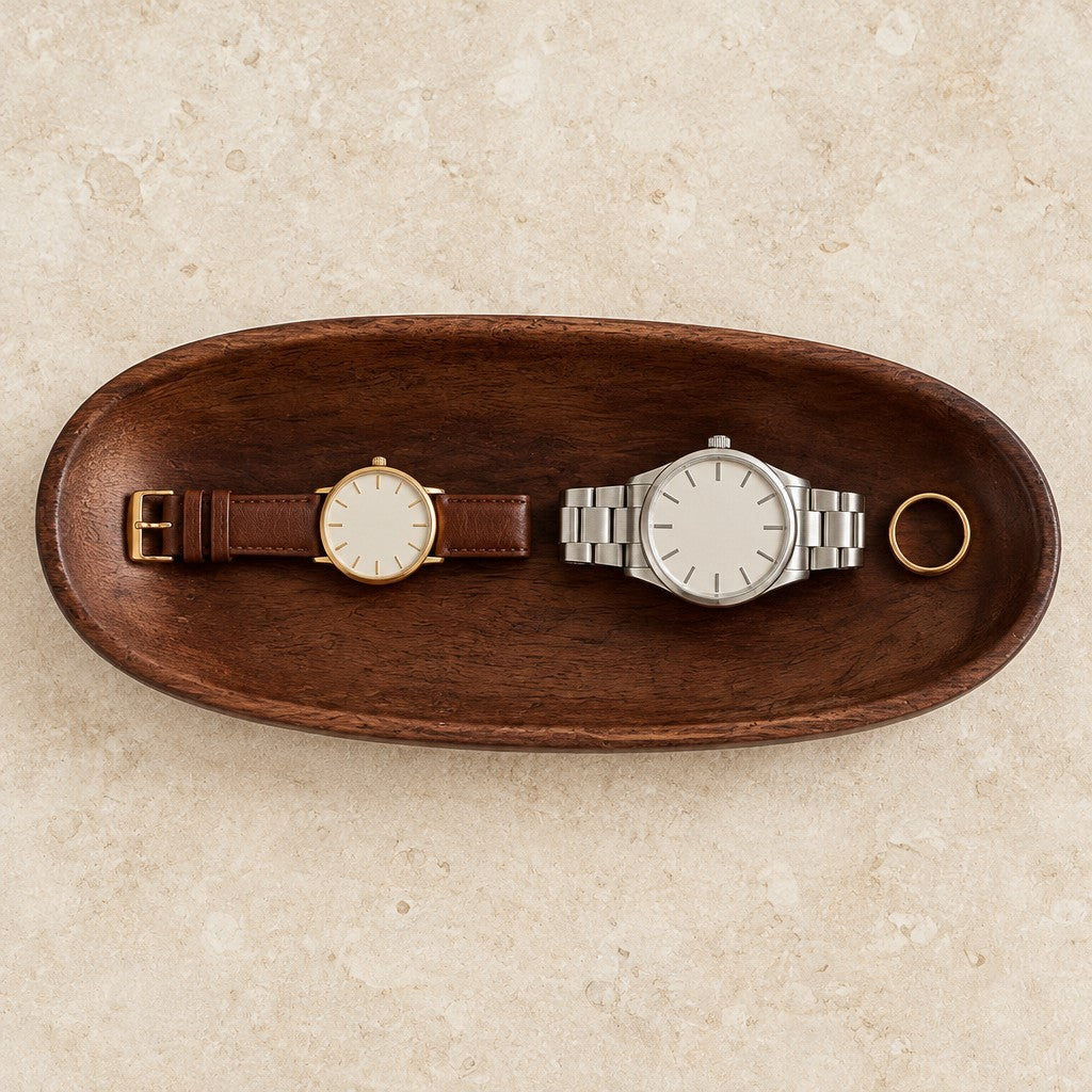 Carved walnut oval valet tray, from above, with watches of different sizes