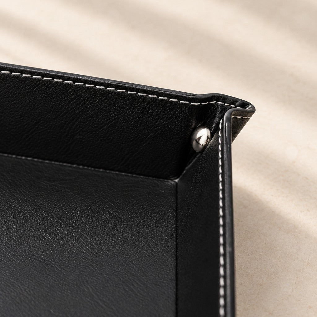 Close-up of the top-stitching and silver snap stud on a corner of the valet tray
