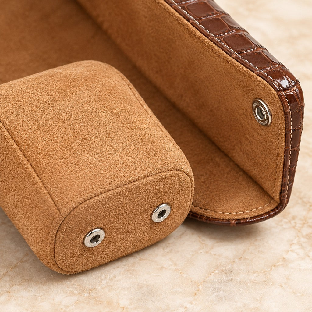 Close-up of a suede-touch pillow and a snap stud on the croco-embossed flap