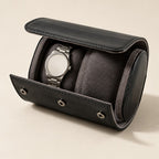 Black leather 2-watch travel roll open, a watch on one of the two gray pillows