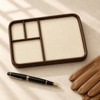 Faux leather valet tray with 4 compartments, beside a fountain pen and leather gloves