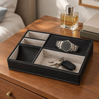 Black faux leather valet tray with 5 compartments, on a chest of drawers, for scale