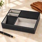 Black faux leather valet tray with 5 compartments, beside a fountain pen and leather gloves