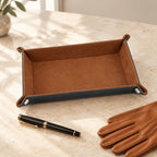 Foldable valet tray beside a fountain pen and leather gloves