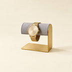 Small gold-tone L-frame watch stand with a gray bar