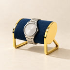 Gold-tone metal watch stand with a watch, three-quarter view