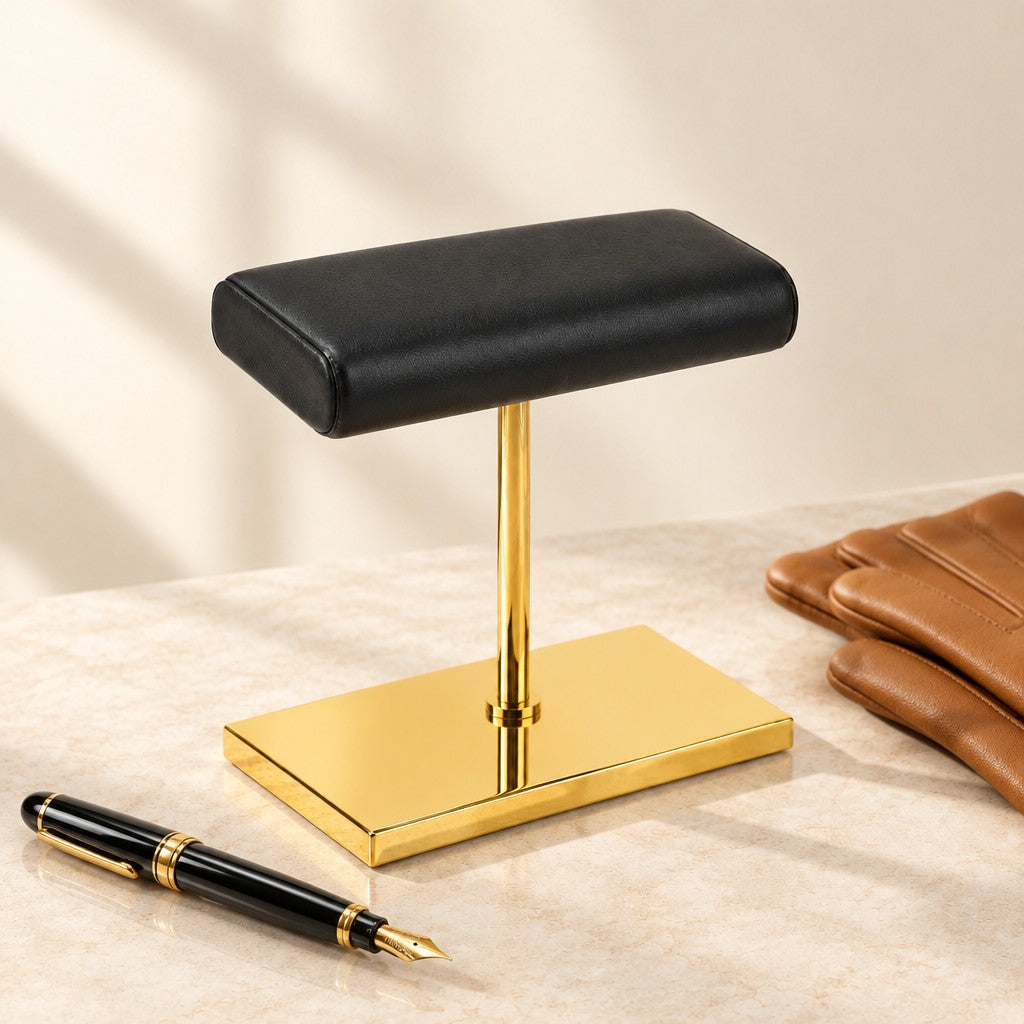Gold-Tone Double Watch Stand with Leather Pillow beside a fountain pen and leather gloves