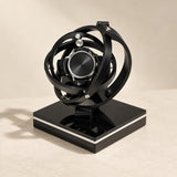 Gyroscope single watch winder with black rings, a watch at the center, on a gloss black base