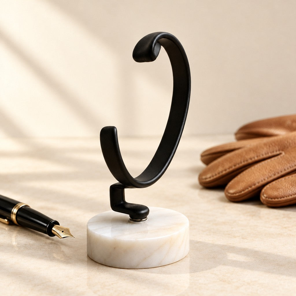 Marble Base C-Ring Watch Stand beside a fountain pen and leather gloves