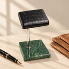 Marble Watch Stand with Croc-Texture Pillow beside a fountain pen and leather gloves