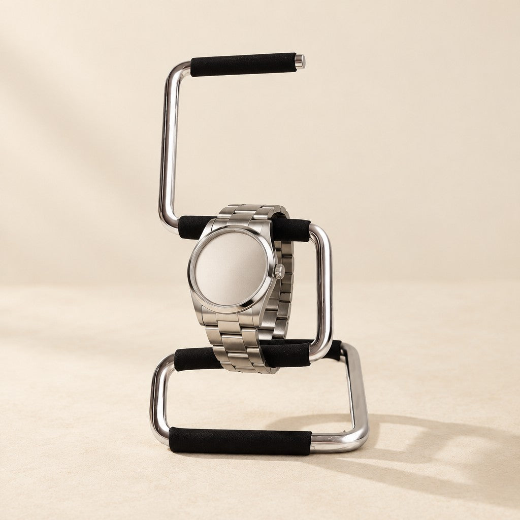 Minimalist bent-metal watch stand with black sleeves holding a watch