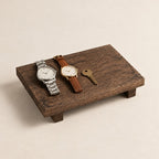 Rustic wooden valet riser holding two watches and a key