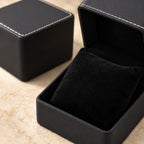 Close-up of the velvet pillow and white stitching of the watch gift box