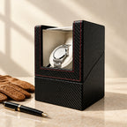 Single watch winder beside a fountain pen and leather gloves