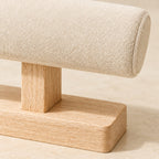 Close-up of the beige velvet cushion and the natural wood post