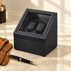 Double watch winder closed, beside a fountain pen and leather gloves