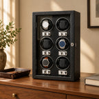 6-watch winder cabinet on a wooden chest of drawers beside a valet tray and a book