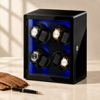 Black 8-watch winder cabinet closed, beside a fountain pen and leather gloves