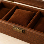 Close-up of the lining and brass-tone clasp of the 4-slot walnut watch box