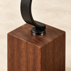 Close-up of the black metal hook fixed into the walnut block