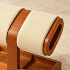 Close-up of the beige pillow and its oval wooden end cap